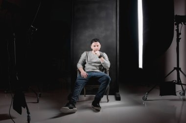 Portre siyah gömlek ve kap koyu arka plan üzerinde erkekte.