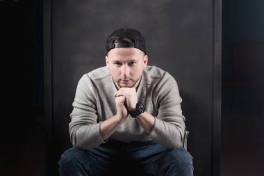 Portre siyah gömlek ve kap koyu arka plan üzerinde erkekte.