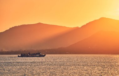 Deniz ve dağların üzerinde dramatik günbatımı manzarası, seyahat konsepti 
