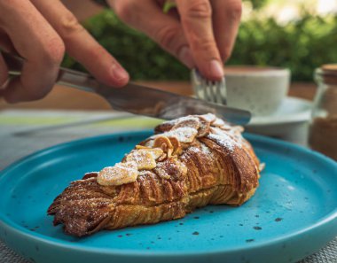 İnsanın kahvaltıda kruvasan yemesine yakın, seyahat konsepti. 