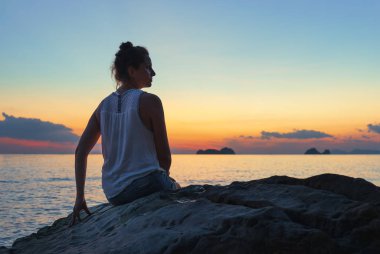 Deniz kıyısındaki kadın gün batımında 