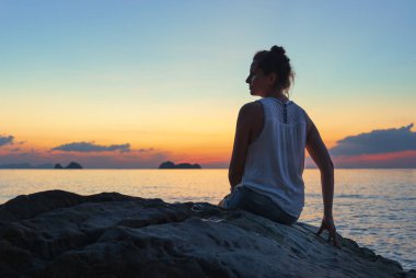 Deniz kıyısındaki kadın gün batımında 