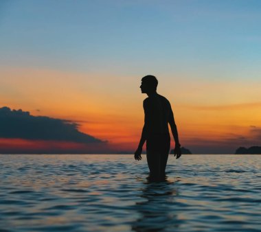 Erkek silueti rengarenk günbatımı arka planında 