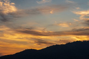 Renkli günbatımına sahip doğal manzara tepenin üstünde bulutlu gökyüzü arkaplanı 