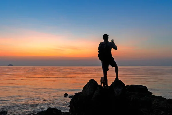 岸上男性摄影师的肖像 拍摄彩色落日 — 图库照片