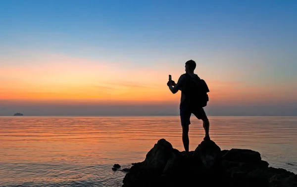岸上男性摄影师的肖像 拍摄彩色落日 — 图库照片
