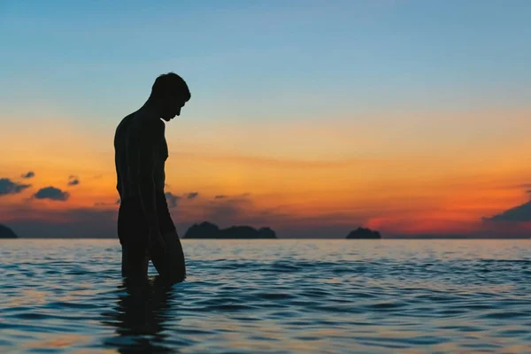 色彩艳丽的日落背景下大海中的男性轮廓 — 图库照片