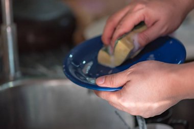 Seramik tabak lavaboda yıkama el yakın çekim.