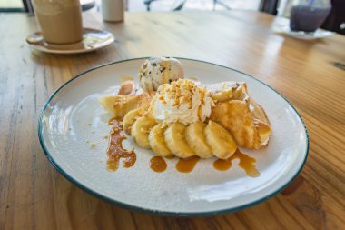 Taze pişmiş karamel muz krep kırbaç krem, cramel sos ve kek ile tepesi, yakın çekim.