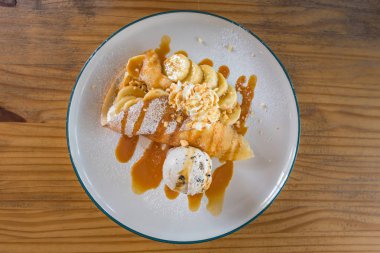 Taze pişmiş karamel muz krep kırbaç krem, cramel sos ve kek ile tepesi, yakın çekim.