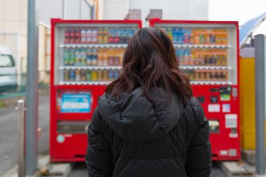 Güzel Asyalı kadının yakın vending machine Nagoya Japonya ürünü seçmek keyfini çıkarın.