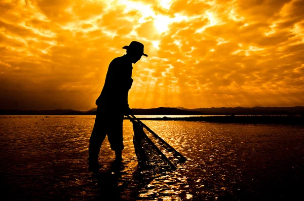 Silhouette de pêcheur au coucher du soleil . — Photo