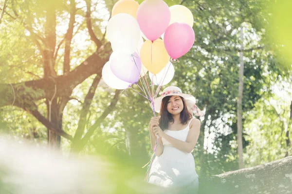 Krásná mladá žena drží vzduchové balónky — Stock fotografie