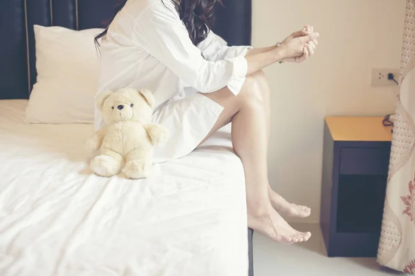 Charming Brunette Sitting Wear White Shirt Pajamas On Bed With Her Brown Teddy Bear. — Stok Foto