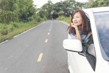 Yeni bir arabanın anahtarlarını alan gülümseyen genç bir kadın. Araba kiralama konsepti. Yolculuğun tadını çıkarıyorum. Seyahat Konsepti.