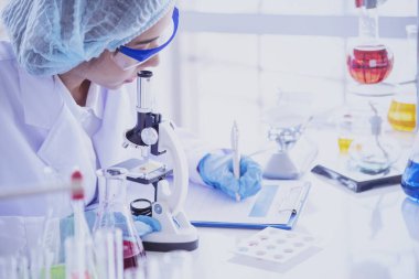Kadın bilim adamı mikroskopa bakar, bilim test tüpü laboratuvar araştırma deneylerindeki bilimsel örnekleri analiz eder ve biyoteknoloji virüse karşı aşı üretir. Kimya bilimi laboratuarı kavramı
