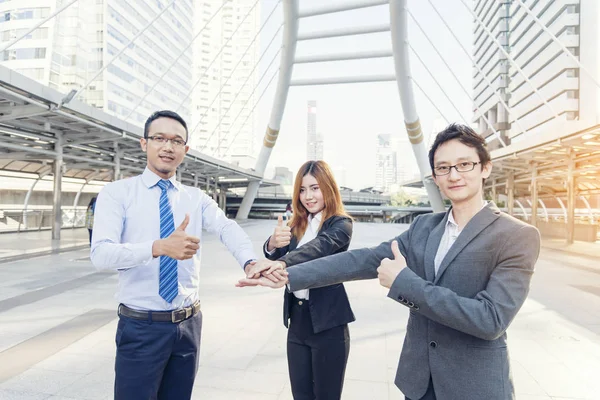 Happy team worker has a business meeting in a modern city.Community Business team conference outside office. Volunteer Team collaborator worker discussing with hands together after complete deal .