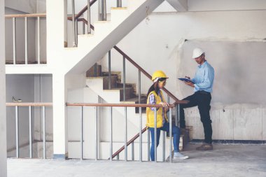 Başarı mühendis emniyet ve mavi baskı planları bina denetlemek için beyaz kask giymek. İnşaat kavramı.