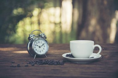 Bahçede kahve fincanı ve saat. İngiliz kahvaltısı çay saati.