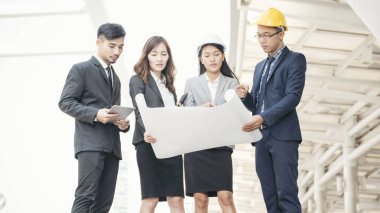 Başarı Ekibi Mühendisi yeni projeyi tartışmak için sarı başlık takıyor. İnşaat konsepti. Lider güvene ilham vermektir. İşbirliği anlaşmalı iş adamı.