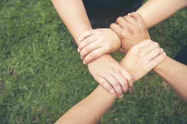 Ortaklık kavramı. Bir grup fotoğrafçı ortak el ele verip birbirlerine güvendiler. İş ortaklarının el ele tutuşması. İnsanların özgünlüğüne dayalı güven işi..
