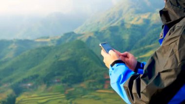 İnternetin süresi dolmak üzere cep telefonu ve mesaj masajına odaklanın ayrıca dağın tepesindeki bir e-postayı da kontrol edin. Teknoloji konsepti olan açık hava yaşam tarzı.