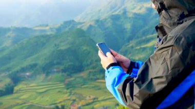 İnternetin süresi dolmak üzere cep telefonu ve mesaj masajına odaklanın ayrıca dağın tepesindeki bir e-postayı da kontrol edin. Teknoloji konsepti olan açık hava yaşam tarzı.