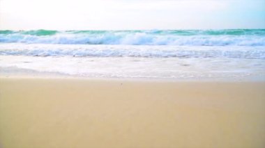 Yazın güneşli bir günde beyaz kum ve mavi denizin olduğu tropik bir sahil. Plajda deniz huzurlu plaj manzaralı köpüklü dalgalar ve mavi deniz tropikal okyanus kumları. deniz kenarında tatil.