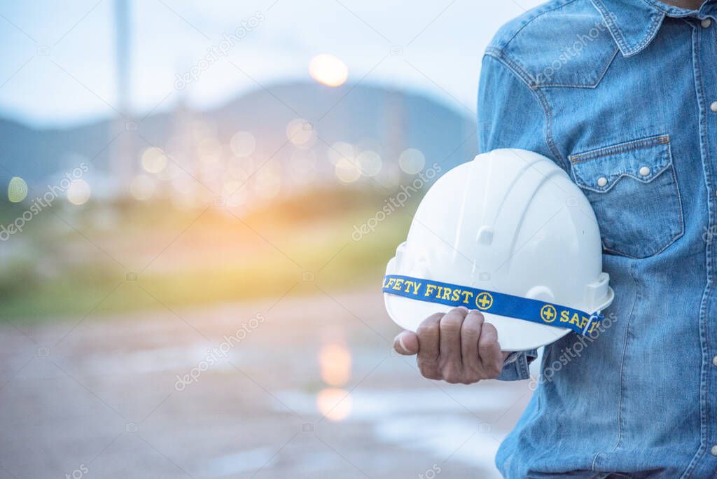 Construction engineer in Safety Suit Trust Team Holding White Yellow Safety hard hat Security Equipment on Construction Site. Hardhat Protect Head for Civil Construction Engineer. Engineering Concept