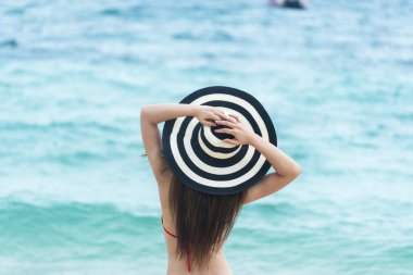 Tropikal cennet sahilinde yaz bikinili kadın tatili. Neşeli kadın sahilde yürürken kırmızı seksi bikini giyiyor. Yazın tropik ada sahilinde açık hava çekimlerinde dinlenme zamanı..