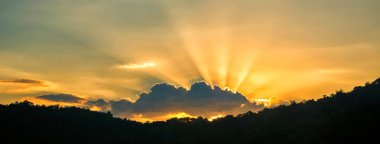 Panorama yaz günbatımı altın bulut yaz mevsimi güneşli gün bulutlu dağ manzarası. Panoramik günbatımı, bulutlu iklim arka planında altın gökyüzü ışığı. Cennetin altın manzarası panoramik afişi