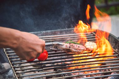 Izgara ızgara et, ateş alevi, bbq yemek pişirme, kömürden yanıyor. Biftek ızgarası, ateş ve dışarıda sigara içmek. Parti için açık havada biftek ızgara. Batı yemekleri konsepti