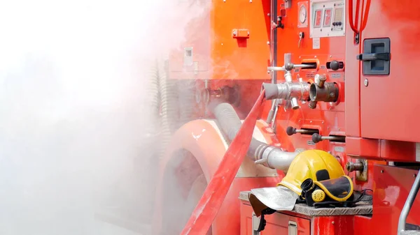 Firefighter fighting with flame using fire hose chemical water foam spray engine. Fireman wear hard hat, body safe suit uniform for protection. Rescue training in fire fighting extinguisher