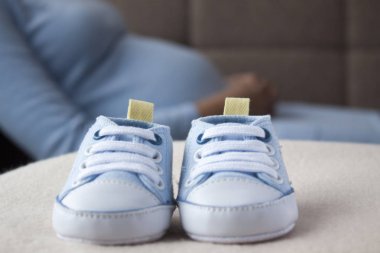 Arka planda hamile bir kadınla Bebek Patiği