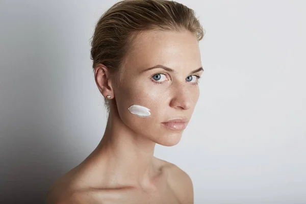 Potret wanita muda kecantikan pengujian wajah perawatan kulit krem — Stok Foto