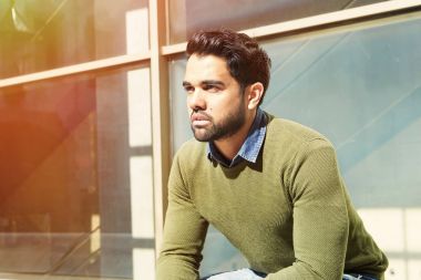 Sıcak bahar gününde açık banch oturan yakışıklı genç.