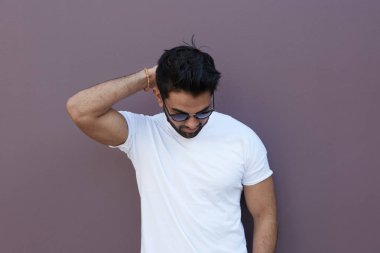 Genç adam sıcak bahar gününde açık duvar yakın kalmak vurguladı.