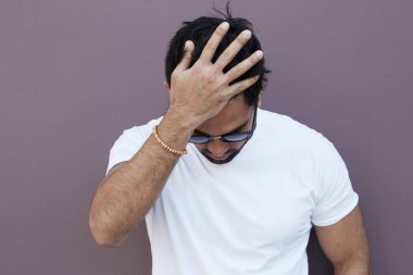 Genç adam sıcak bahar gününde açık duvar yakın kalmak vurguladı.