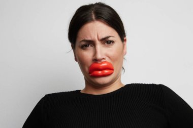Sahte botox dudaklı kadın portresi kapatın. Beyaz arka plan.
