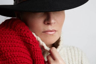Şapka ve beyaz arka plan üzerinde eğleniyor kazak mutlu genç kadın moda