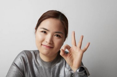 Genç Asyalı kadın beyaz arka plan üzerinde izole bir eğleniyor. Yakın çekim.