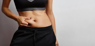 Aşırı mide yağ pinching bir kadının el Close-Up.