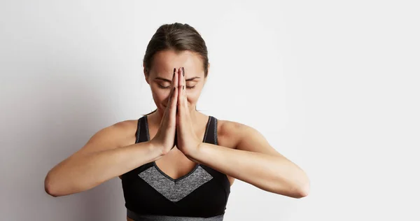 Woman practicing yoga, sitting in lotus position, hands together. — Stock Photo, Image