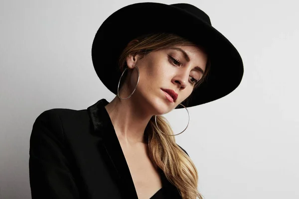Retrato de mulher bonita e moda vestindo chapéu preto no fundo branco. Faz asneira. . — Fotografia de Stock