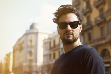 Kendine güvenen iş adamı. Büyük şehirde yürüyüş başarılı genç adam. Streight kameraya bakıyor.