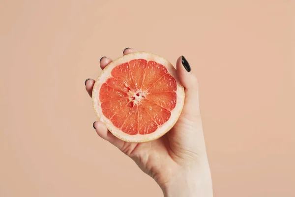 Hand met een gesneden fris oranje close-up. Geïsoleerd op een achtergrond met kopie ruimte voor tekst. Schoon eten concept — Stockfoto