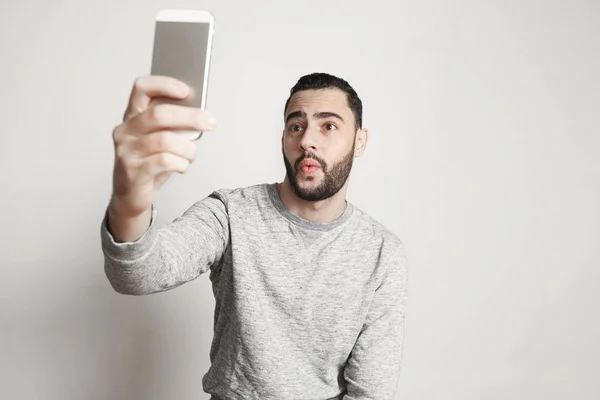 Ember fog selfie fénykép-sejt szúró telefon boldog mosollyal fiatal jóképű srác-fehér háttér — Stock Fotó