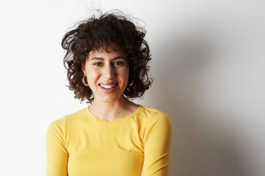 Neşeli ve sevimli bir gülümseme ile kameraya bakarak mutlu neşeli genç kadın. Öğrenci üniversiteden sonra. Senin metin için yer.