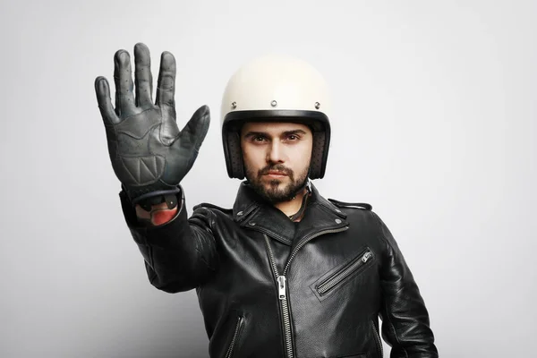 Közelkép egy fehér sisakos motoros fickóról, aki stoptáblákat csinál a kezével. Elszigetelt. — Stock Fotó