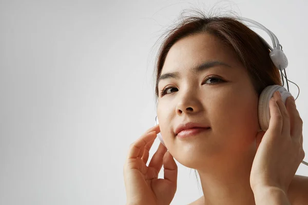 Portret chińskiej kobiety pozującej na białym tle z dużymi słuchawkami. Izolacja. — Zdjęcie stockowe